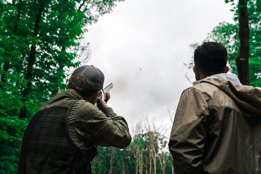 Two friends shooting clays in the woods
