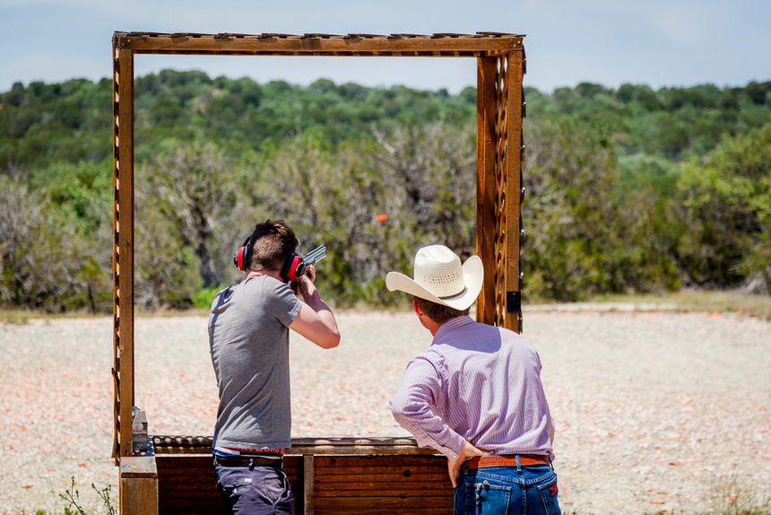 An instructor coaching a shooter at a sporting clays stand